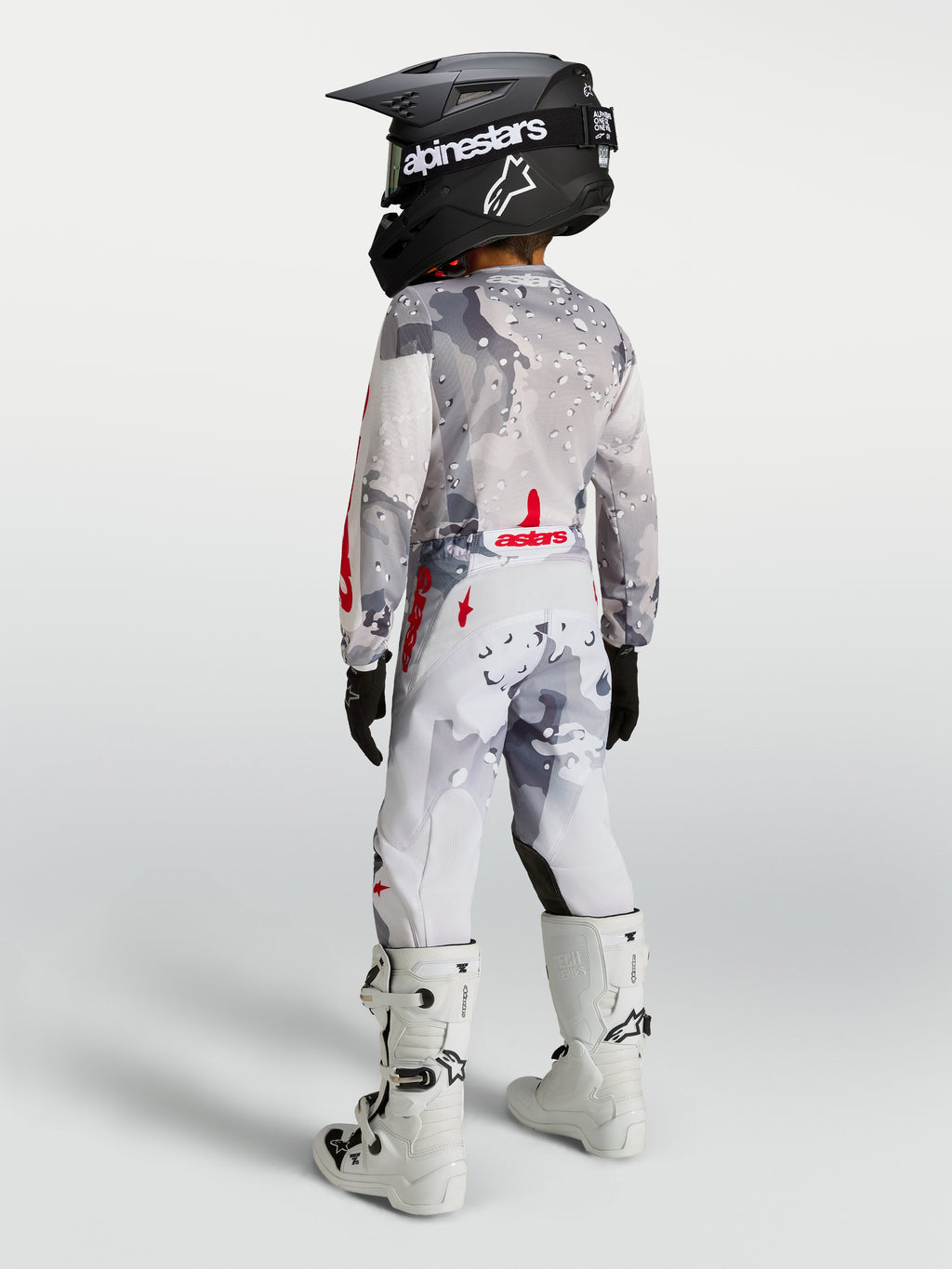 Alpinestars Fluid Lone Junior 2027, ensemble de motocross gris camouflage et blanc à touches rouges, vue de dos.