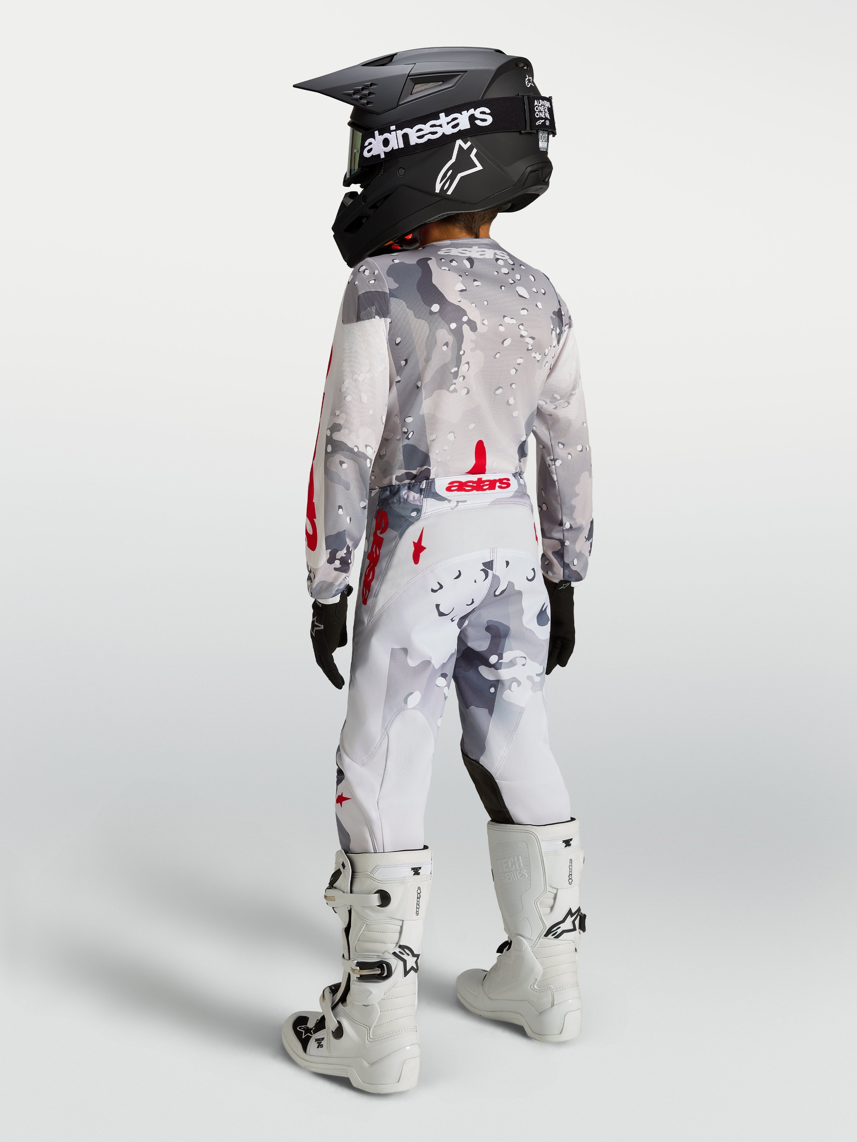 Alpinestars Fluid Lone Junior 2027, ensemble de motocross gris camouflage et blanc à touches rouges, vue de dos.