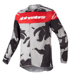 Alpinestars Youth 2023 Racer Tactical Jersey, maillot de motocross, Cast Gray Camo et Mars Red, avec une bande rouge horizontale sur la poitrine et le logo Alpinestars blanc, motif camouflage gris et noir, tissu léger évacuant l'humidité pour la conduite tout-terrain