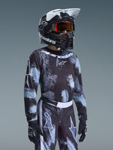 Alpinestars 2026 Youth Fluid Lahnd Jersey, Motocross Jersey, Iron Camo pattern in black and light blue, worn by a youth rider with matching pants and black helmet, coordinated off-road racing gear.