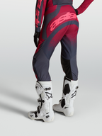 Alpinestars Stella Techstar Swan Pants shown from behind, featuring Crimson and Dark Gray textile panels, paired with white Tech 10 motocross boots.