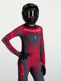 Alpinestars Maillot Stella Techstar Swan, maillot de motocross pour femme, rouge et gris foncé, avec perforations laser pour la ventilation, porté par un mannequin avec équipement complet