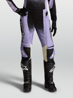 Alpinestars Stella Techstar Swan, pantalon de motocross pour femme, violet et noir avec accents en cuir crème, porté avec des bottes tout-terrain noires