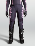 Pantalons Stella Fluid Apex V2, pantalon de motocross pour femme gris anthracite et rose, design pré-courbé, porté avec bottes et gants de moto Alpinestars
