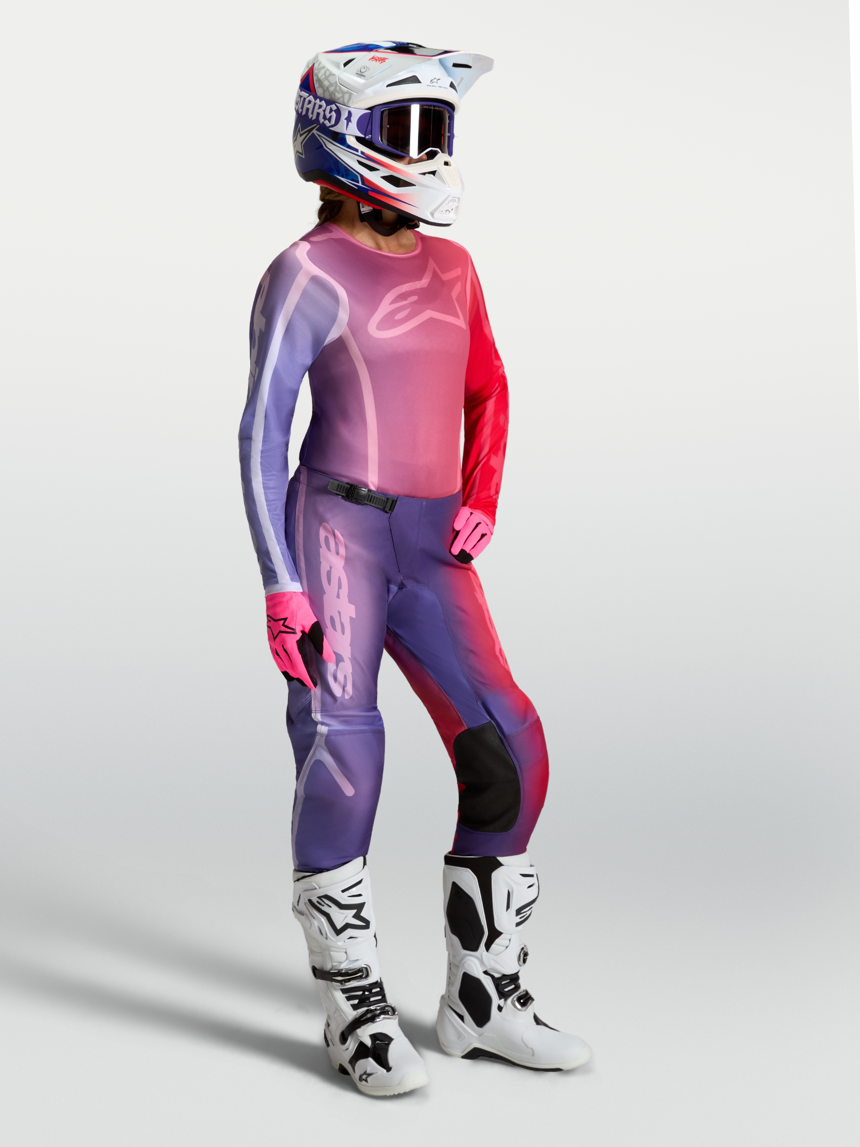 Alpinestars Stella Fluid Kepler Jersey, women's motocross top in Purple and Rouge Red, worn with matching pants and white boots.