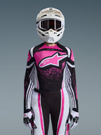 Ensemble d'équipement Alpinestars Stella Techstar Nomur 2026, tenue de motocross pour femme, rose, noir et blanc avec un grand logo étoile, comprenant un maillot, un pantalon et des gants assortis avec un casque blanc, vue de face sur fond gris