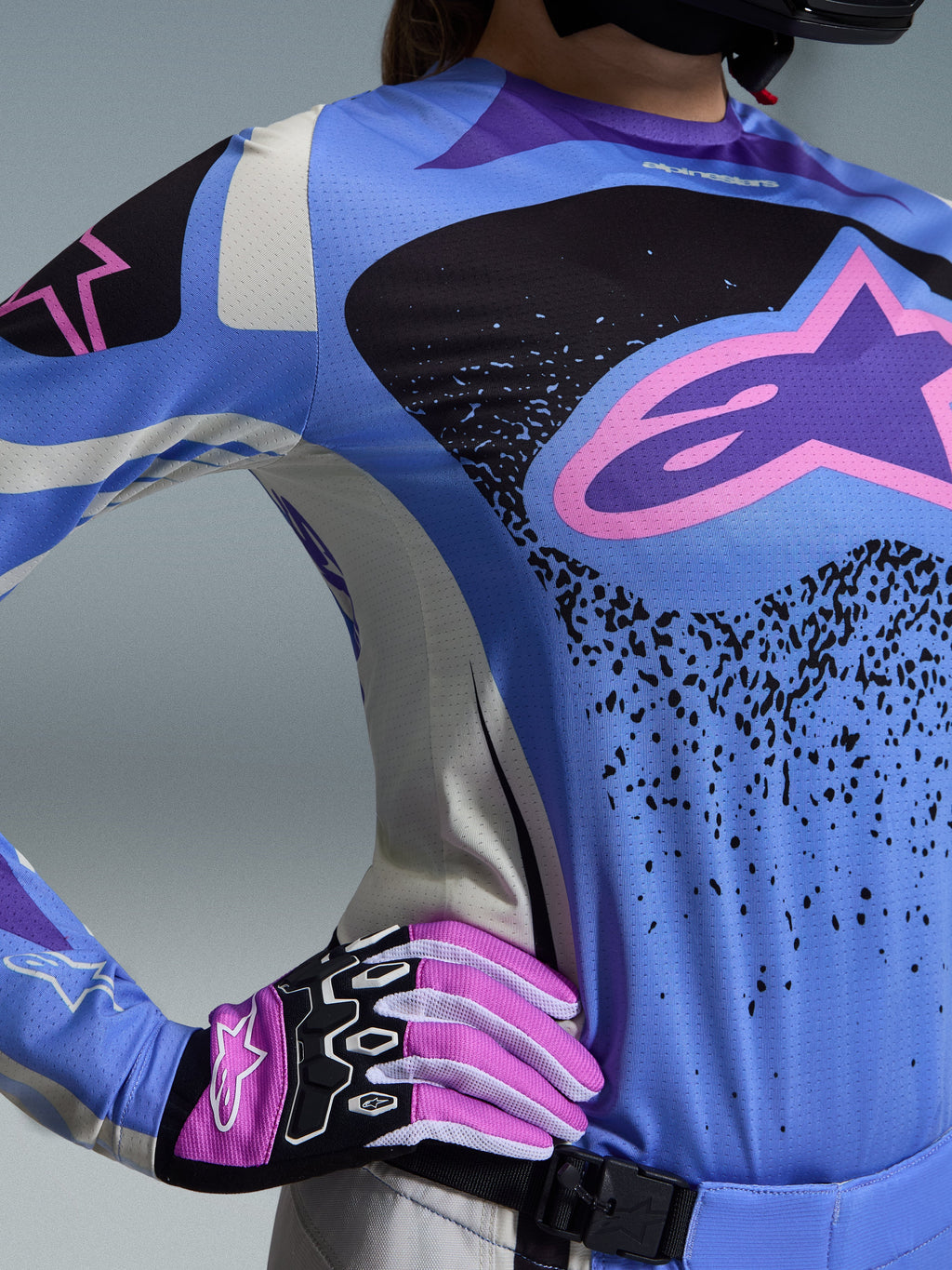 Ensemble d'équipement Alpinestars 2026 Stella Techstar Nomur, équipement de motocross pour femme, bleu clair et noir avec logo étoile rose, porté avec des gants roses et blancs assortis, coupe de course athlétique conçue pour une performance d'élite sur tous les terrains.