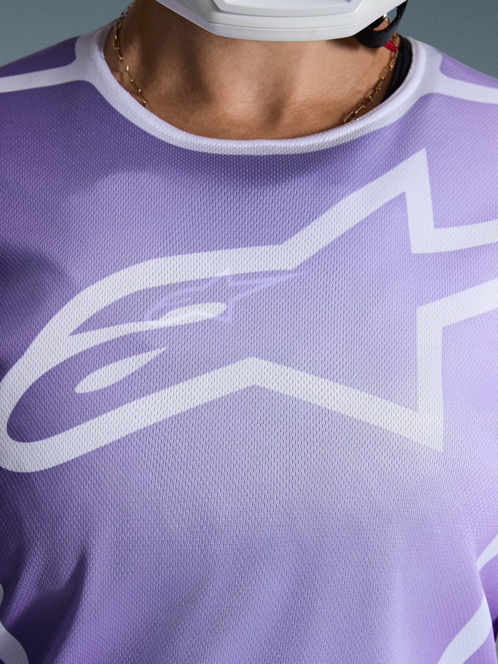 Alpinestars 2026 Stella Fluid Apex Jersey, Close-up of chest, Purple with white graphics, featuring a large white Astars logo on mesh polyfabric construction.