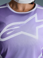 Alpinestars 2026 Stella Fluid Apex Jersey, Close-up of chest, Purple with white graphics, featuring a large white Astars logo on mesh polyfabric construction.