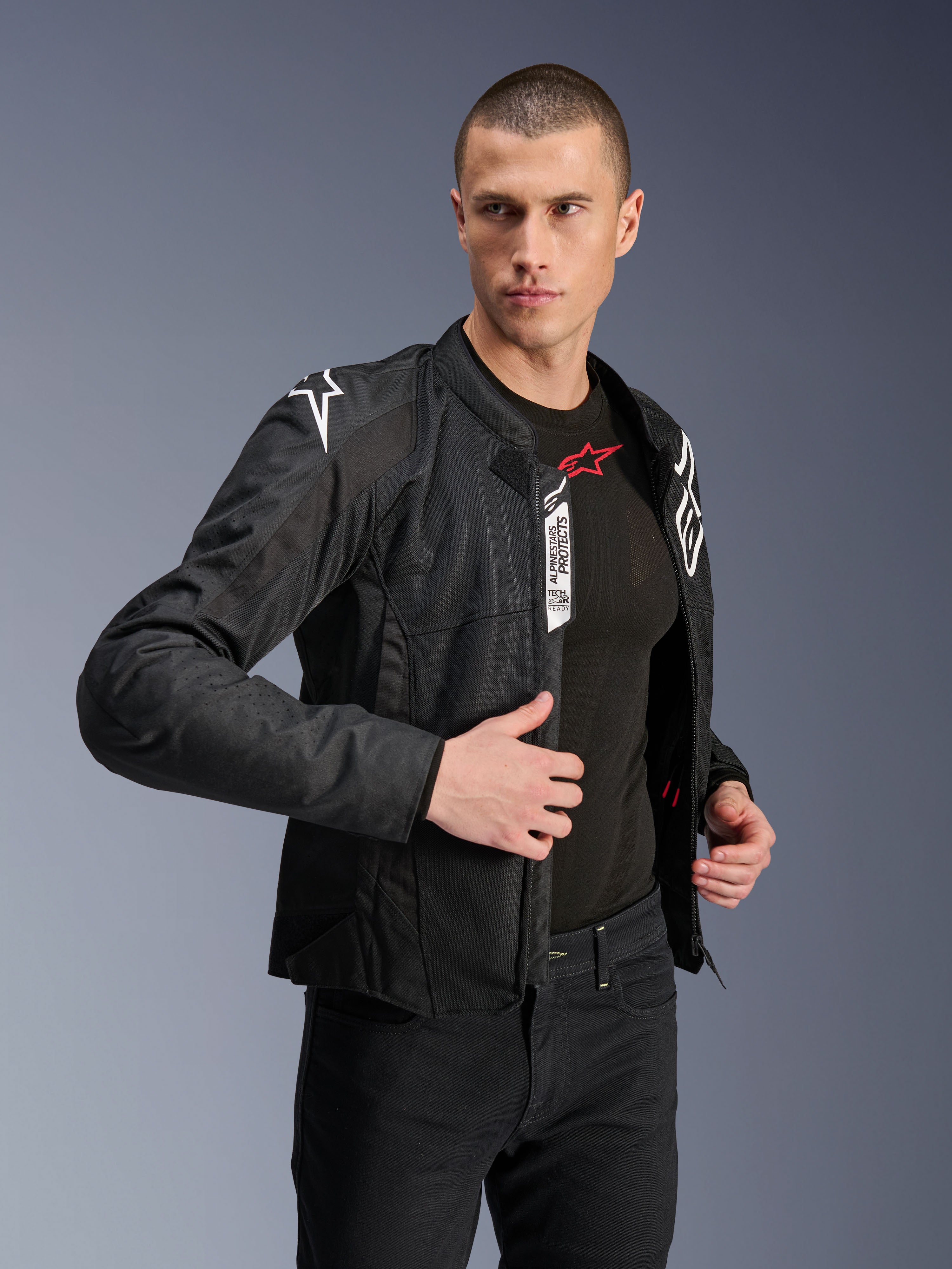 Veste Alpinestars Viper Air V4, veste de moto en textile noir, portée par un mannequin homme avec un jean noir et une sous-couche, avant ouvert montrant les étiquettes Tech-Air Ready et Alpinestars Protects, logos blancs sur les épaules, panneaux en mesh pour la circulation de l'air