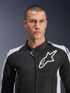 Modèle masculin portant la veste Alpinestars Viper Air V4 en noir et blanc, avec panneaux en maille technique pour la circulation de l'air, logo étoile Alpinestars blanc sur la poitrine, équipement de route sportif pour moto