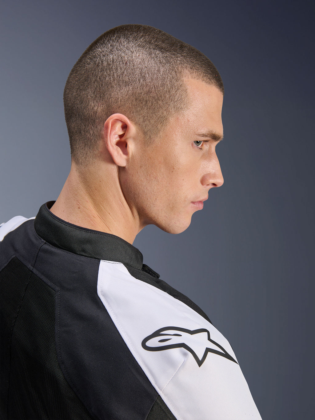 Veste Alpinestars Viper Air V4, noir et blanc, profil latéral d'un mannequin homme portant la veste, avec panneau d'épaule blanc et logo Alpinestars noir, construction en maille technique pour la ventilation, équipement de route sportif pour moto