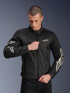 Alpinestars T-Dyno Air Jacket, Black, textile motorcycle jacket with 3D mesh panels and white sleeve logos, worn by a model zipping the front, urban street riding style