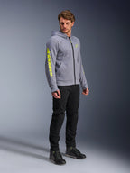 Alpinestars Chrome V2 Sport Hoodie, Gray Heather and Fluo Yellow, worn by a male model with black pants and black riding shoes, featuring bold yellow branding on the sleeve and chest, casual urban motorcycle riding gear
