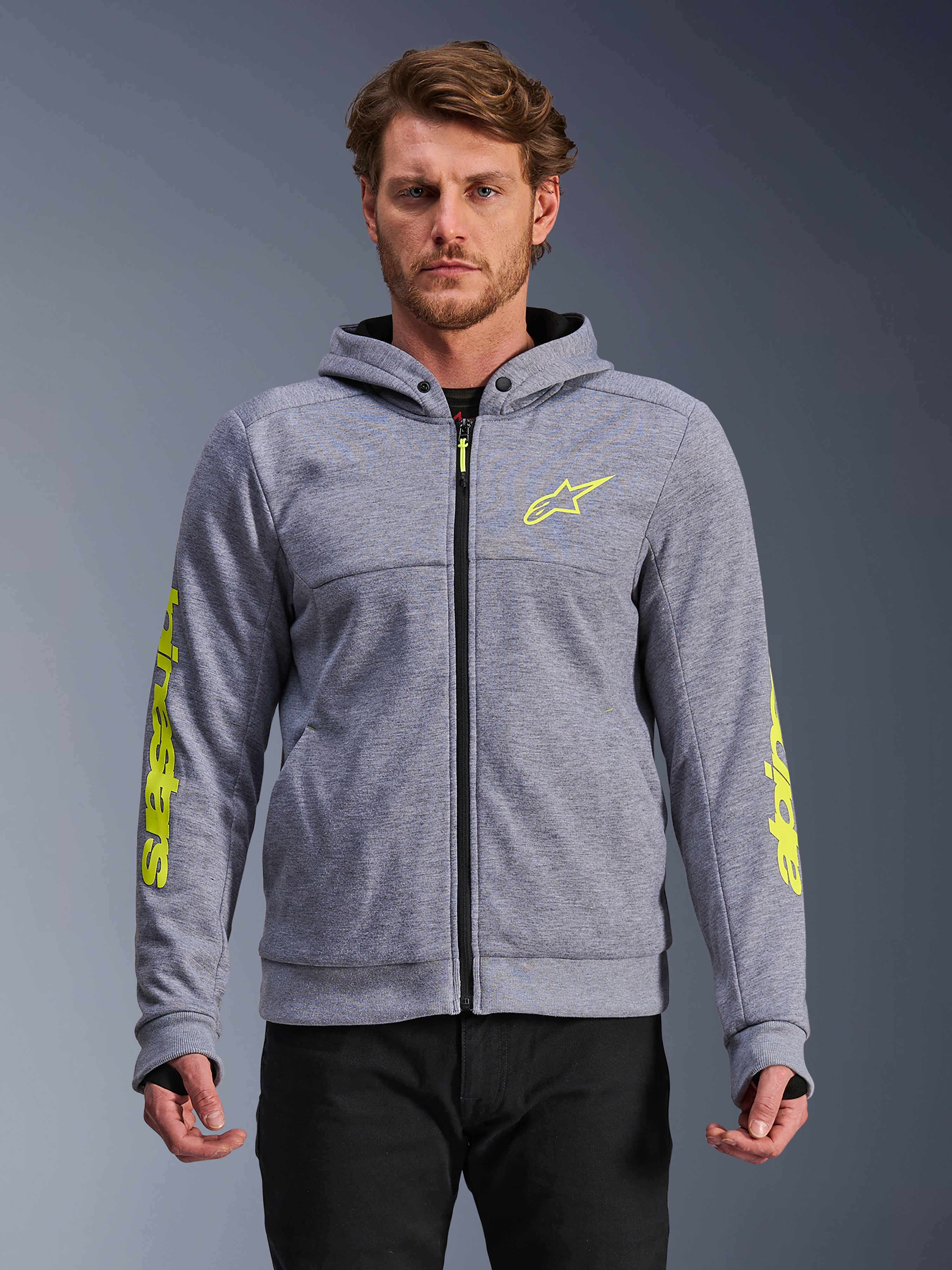 Alpinestars Chrome V2 Sport Hoodie, gris chiné et jaune fluo, sweat à capuche zippé pour moto avec logo étoile jaune sur la poitrine et marquage jaune sur les manches, passants pour les pouces et fermeture éclair noire, texture en polaire technique, équipement de conduite urbain décontracté
