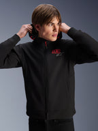 Sweat à capuche Alpinestars MM93 Radium Tech, veste de moto urbaine, noir avec logos rouges et argentés, porté par un mannequin homme, doté d'une fermeture éclair intégrale et de poignets côtelés, vêtement de sport automobile décontracté