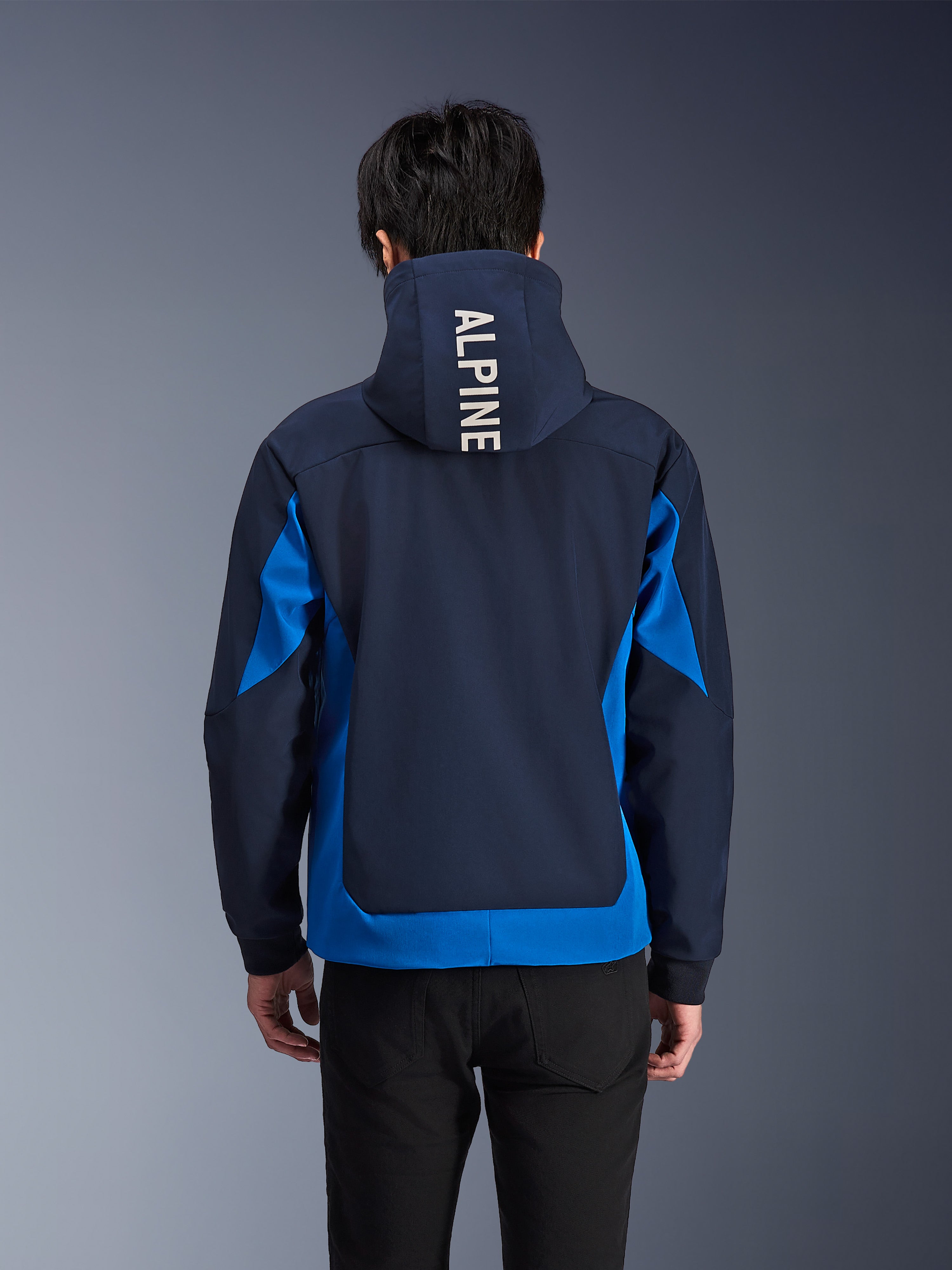 Alpinestars Radium Tech Hoodie, Night Navy and Royal Blue motorcycle jacket, back view showing white 'ALPINE' branding on the hood, urban performance gear with athletic fit and contrasting color panels