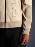 Alpinestars Radium Tech Hoodie en Mastic Aluminum, vue rapprochée de la poitrine et de la manche, marquage vertical noir 'Alpinestars One Goal One Vision', poignet côtelé extensible et détail de fermeture éclair, veste de moto textile urbaine
