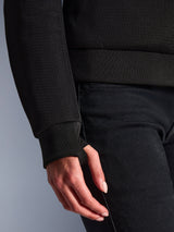 Gros plan sur le sweat à capuche Alpinestars Stella Chrome Superairflow, noir, montrant le textile en maille 3D détaillé et le poignet extensible côtelé avec passe-pouce intégré pour un ajustement sûr.