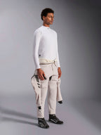 Haut à manches longues Alpinestars ZX Evo V3, sous-vêtement de course automobile blanc résistant aux flammes, porté par un mannequin avec une combinaison de course nouée autour de la taille, couche technique légère avec col montant et détails de logo.