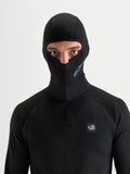 Alpinestars At 8 Merino Cagoule, cagoule de moto noire portée par un modèle avec une construction thermique en mélange de mérinos et un design à visage ouvert