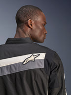 Alpinestars T-Dyno WR Jacket, Textile Motorcycle Jacket, Black Dark Gray and Ecru, close-up of the upper back and shoulder with horizontal stripes and Alpinestars star logo, worn by a model, heritage-inspired design for road riding