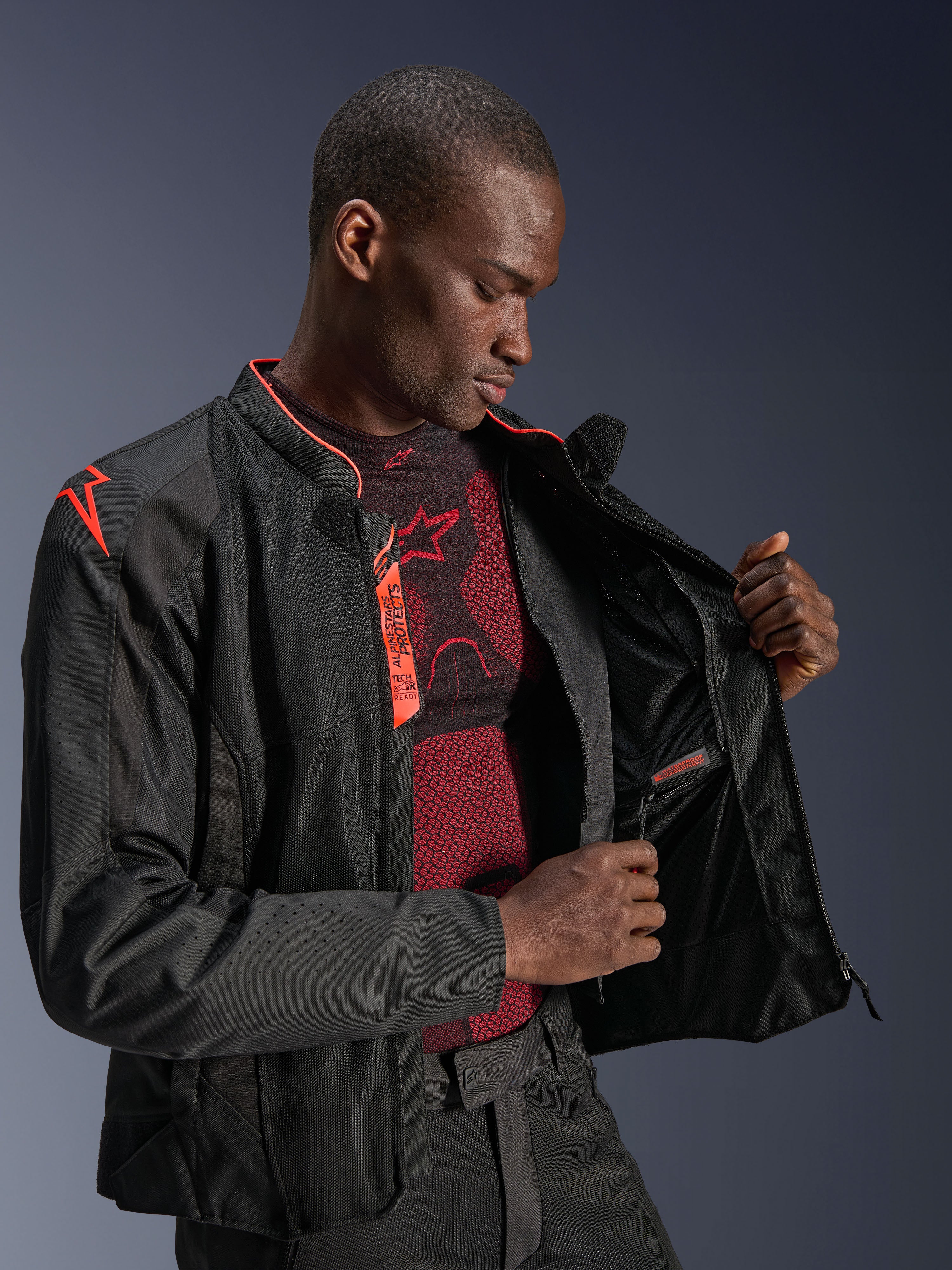 Alpinestars Viper Air V4 Jacket, Black Red Fluo, motorcycle jacket with tech mesh panels, male model demonstrating the waterproof inner compartment and interior lining, features red fluo accents and Tech-Air Ready branding.