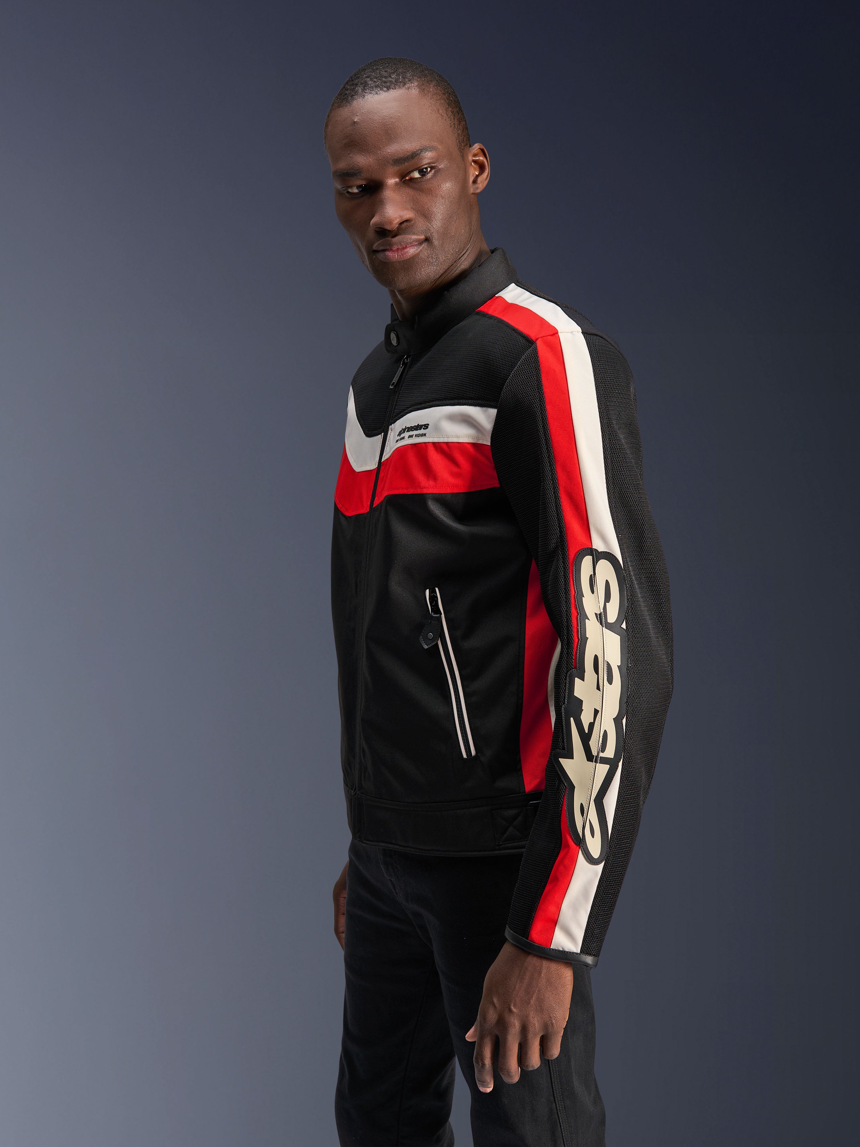 Mannequin homme portant la veste Alpinestars T-Dyno Air en Noir, Rouge Éclatant et Écru, veste de moto en textile d'inspiration vintage avec panneaux en maille 3D, rayures rouges et blanc cassé audacieuses, et logo Alpinestars distinctif sur la manche.