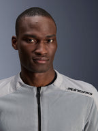 Veste Alpinestars C-1 Air en argent et gris, portrait rapproché d'un motard, avec panneaux en mesh technique et marquage noir sur l'épaule, équipement de moto urbain contemporain