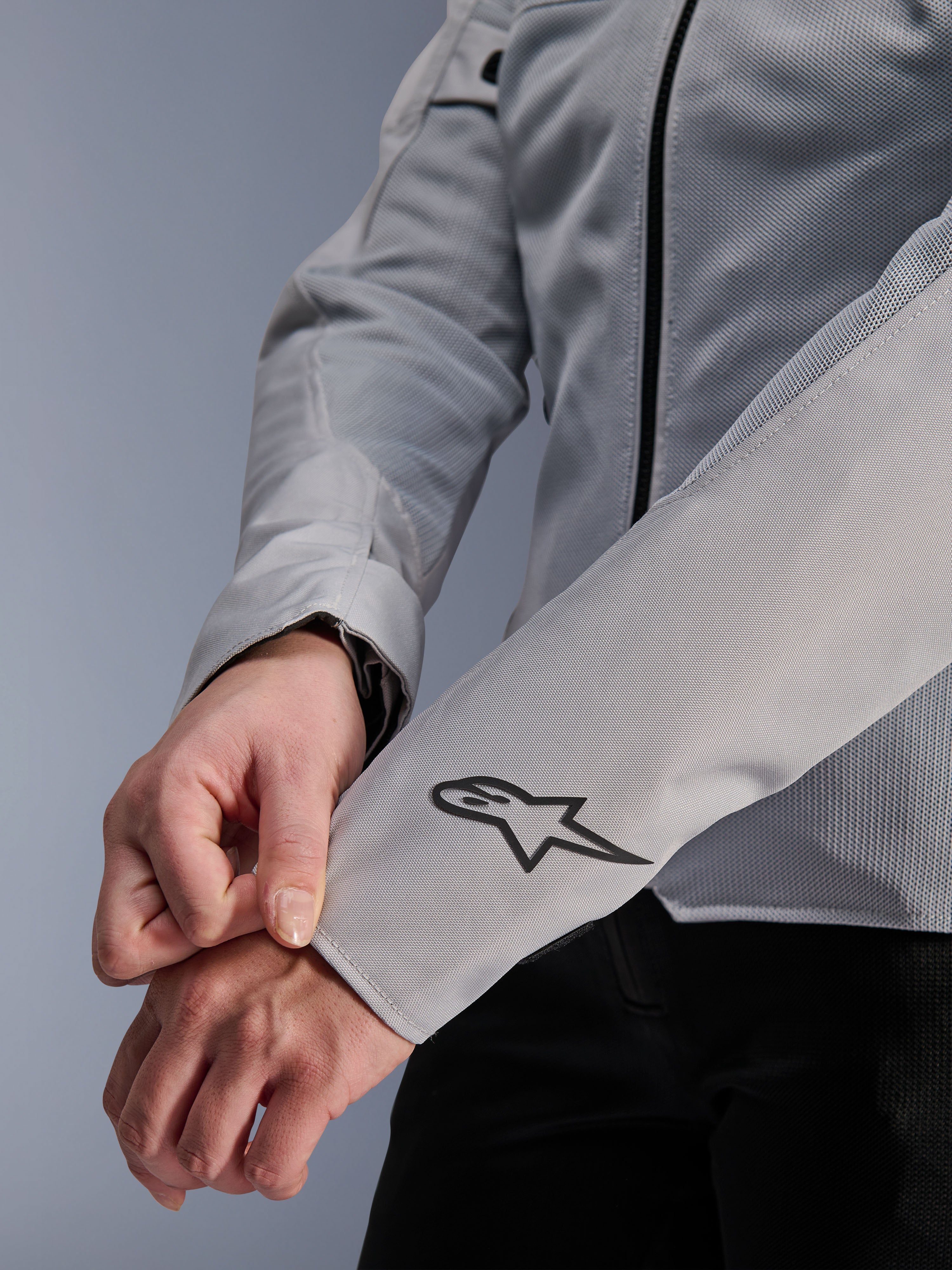 Gros plan de la veste Alpinestars Stella C-1 Air en coloris argent, dotée d'une construction en maille technique et d'un logo Alpinestars noir sur la manche gauche, veste de moto urbaine pour femme avec marquage réfléchissant.