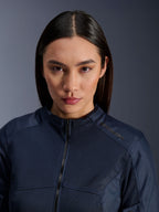 Modèle féminin portant la veste Alpinestars Stella C-1 Air bleu foncé, gros plan montrant la texture textile en maille respirante, fermeture éclair à l'avant et logo Alpinestars sur le col, vêtement de moto urbain élégant