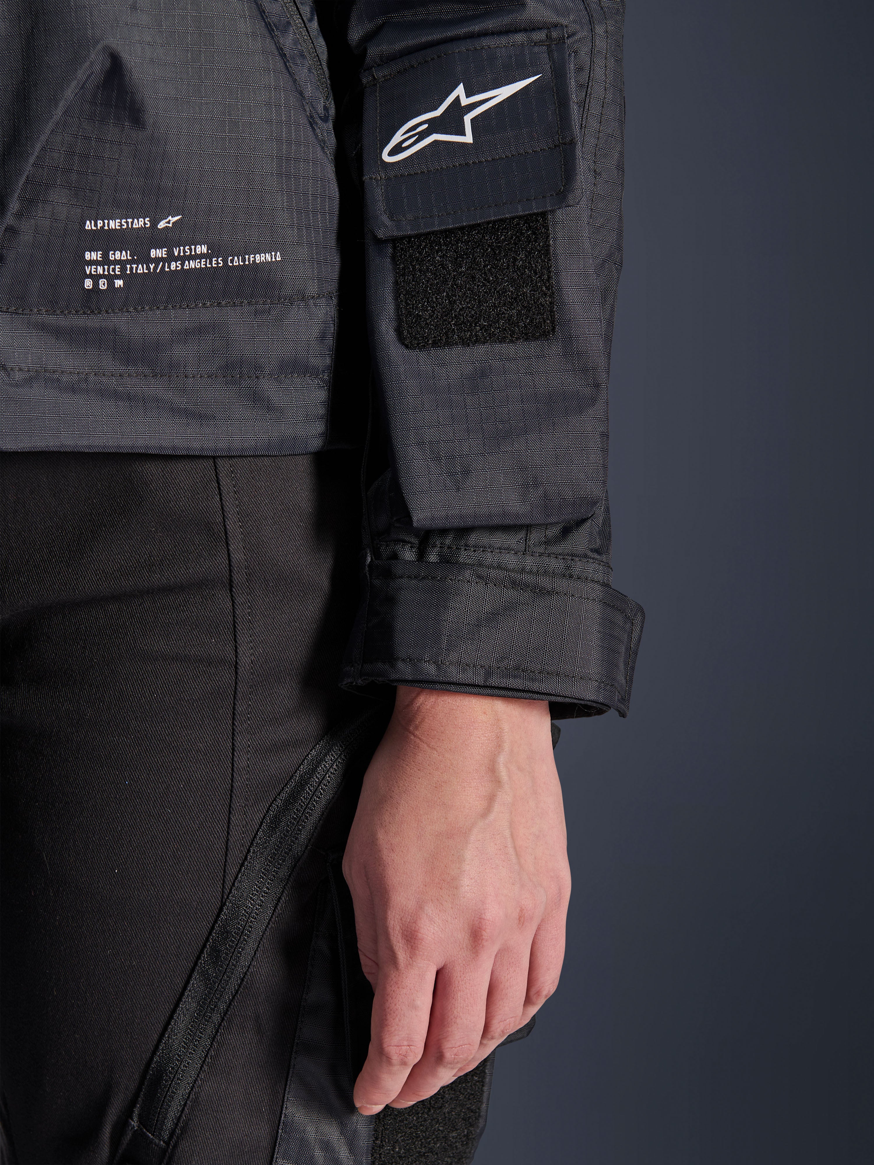 Veste Alpinestars Molly Air, gros plan sur le textile ripstop noir, logo Astar blanc sur la poche de manche avec écusson velcro, poignet réglable et marquage imprimé sur le côté, équipement de moto urbain pour femme