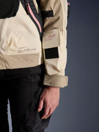 Veste Alpinestars Molly Air, veste de moto urbaine pour femme, Sand Pink Almond, vue latérale rapprochée montrant la poche sur la manche avec logo rose, empiècement velcro noir et texte de mission de la marque dans le bas du dos, matériau ripstop léger