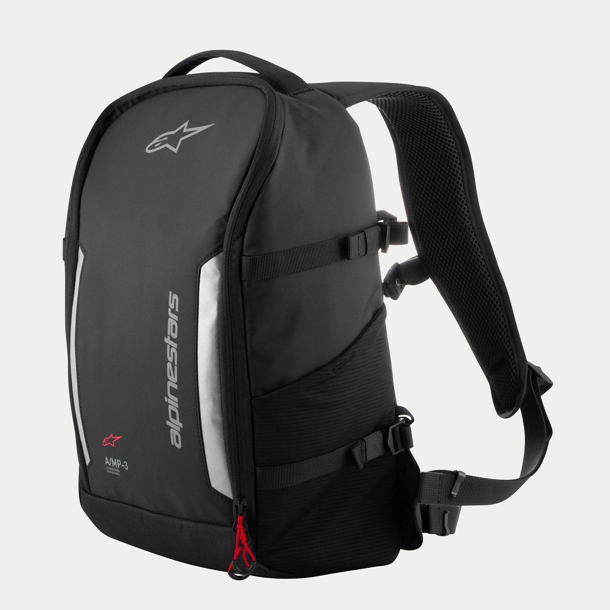 Sac à dos Alpinestars AMP3, sac de moto technique noir avec logos blancs, panneaux réfléchissants argentés, tirettes de fermeture éclair rouges, sangles de compression latérales ajustables et bretelles en mesh rembourrées.