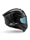 Alpinestars Supertech R10 Solid, casque de moto de course, carbone noir mat et brillant, construction en fibre de carbone, profil latéral, visière teintée bleue, design aérodynamique avec ailerons, logo blanc, protection haute performance de niveau MotoGP