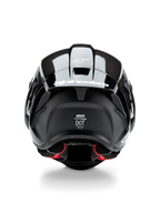 Casque Alpinestars Supertech R10 Solid, casque de moto, noir carbone mat et brillant, vue arrière avec texture en fibre de carbone, spoiler aérodynamique avec logo Alpinestars blanc, étiquettes de certification de sécurité DOT et ECE, et rembourrage intérieur rouge
