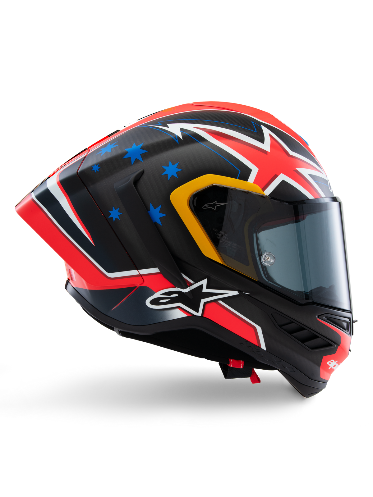 Casque Alpinestars Supertech R10 Miller Limited Edition, casque intégral de course, carbone mat avec graphismes rouges, blancs et bleus, motifs d'étoiles bleues et liseré de visière jaune, profil aérodynamique avec écran fumé foncé, équipement de sécurité moto haute performance