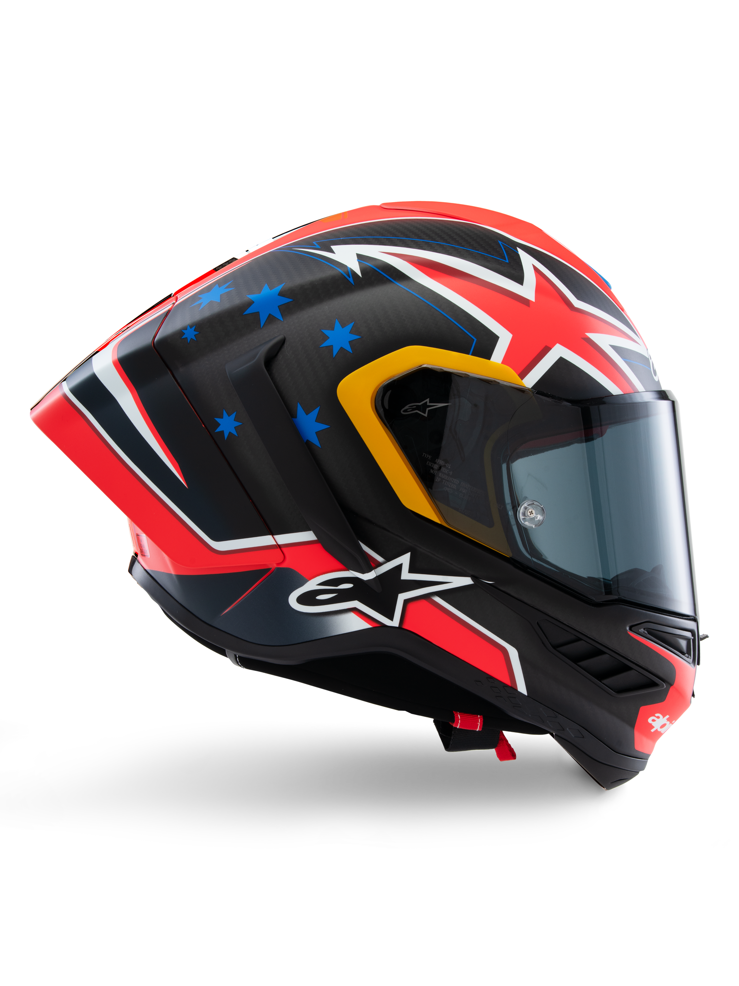 Alpinestars Supertech R10 Miller Limited Edition Helmet, full-face racing helmet, matte carbon with red white and blue graphics, blue star accents and yellow visor trim, aerodynamic profile with dark smoke shield, high-performance motorcycle safety gear