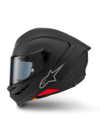 Casque Alpinestars S-R7 Solid, casque de moto intégral, noir mat, vue de profil, avec logo Astars argenté sur le côté, design aérodynamique avec spoiler intégré et ventilations de mentonnière, et accents rouges et orange à la base.