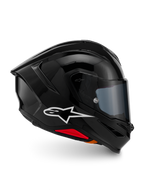 Casque Alpinestars S-R7 Solid, casque intégral de moto, noir brillant, vue de profil avec logo A-star blanc, coque aérodynamique profilée avec spoiler intégré et accents rouges à la base, conçu pour la course et les performances sportives.