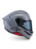 Casque Alpinestars S-R7 Solid, casque de moto intégral, gris brillant, vue de profil, coque aérodynamique gris brillant avec logo noir et accents rouges à la base, équipement de haute performance pour la course et la conduite sportive