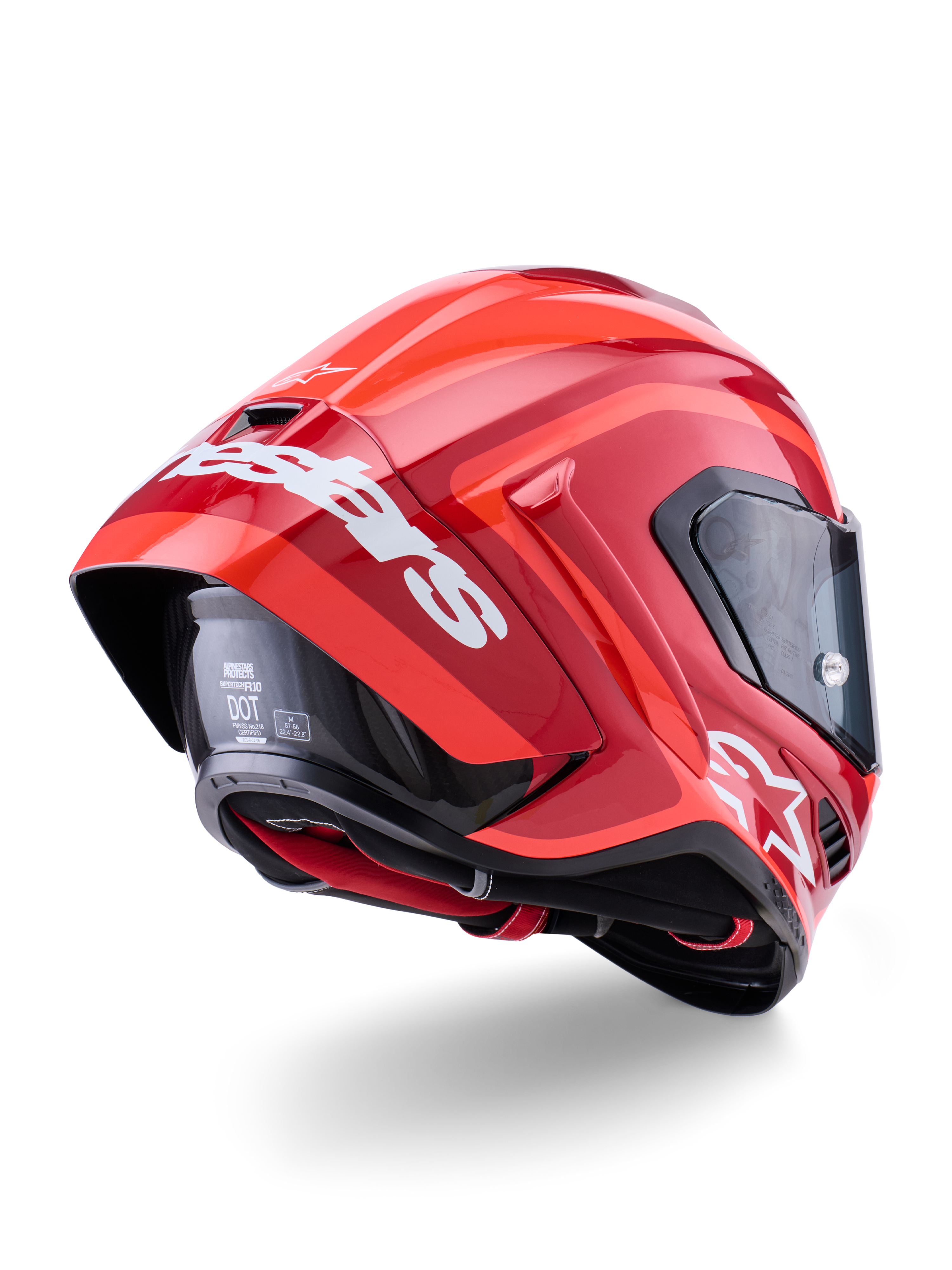 Casque Alpinestars Supertech R10 Arius, rouge brillant avec marquage blanc, vue de trois-quarts arrière montrant le spoiler aérodynamique, construction de la calotte en fibre de carbone et profil de course épuré avec visière foncée