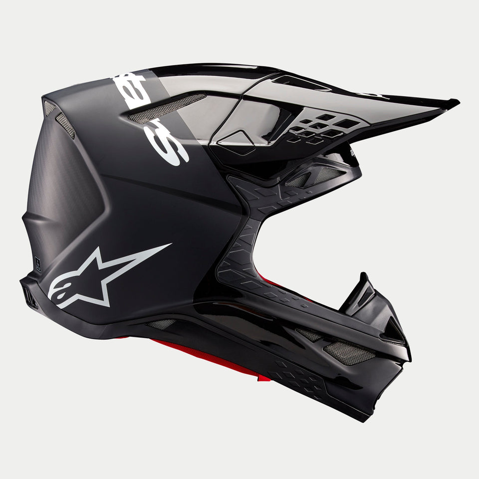 Alpinestars Supertech M10 Flood Helmet ECE, casque de motocross, noir et gris foncé avec finition mate et brillante, vue de profil présentant un design aérodynamique, une visière intégrée et le logo Alpinestars blanc