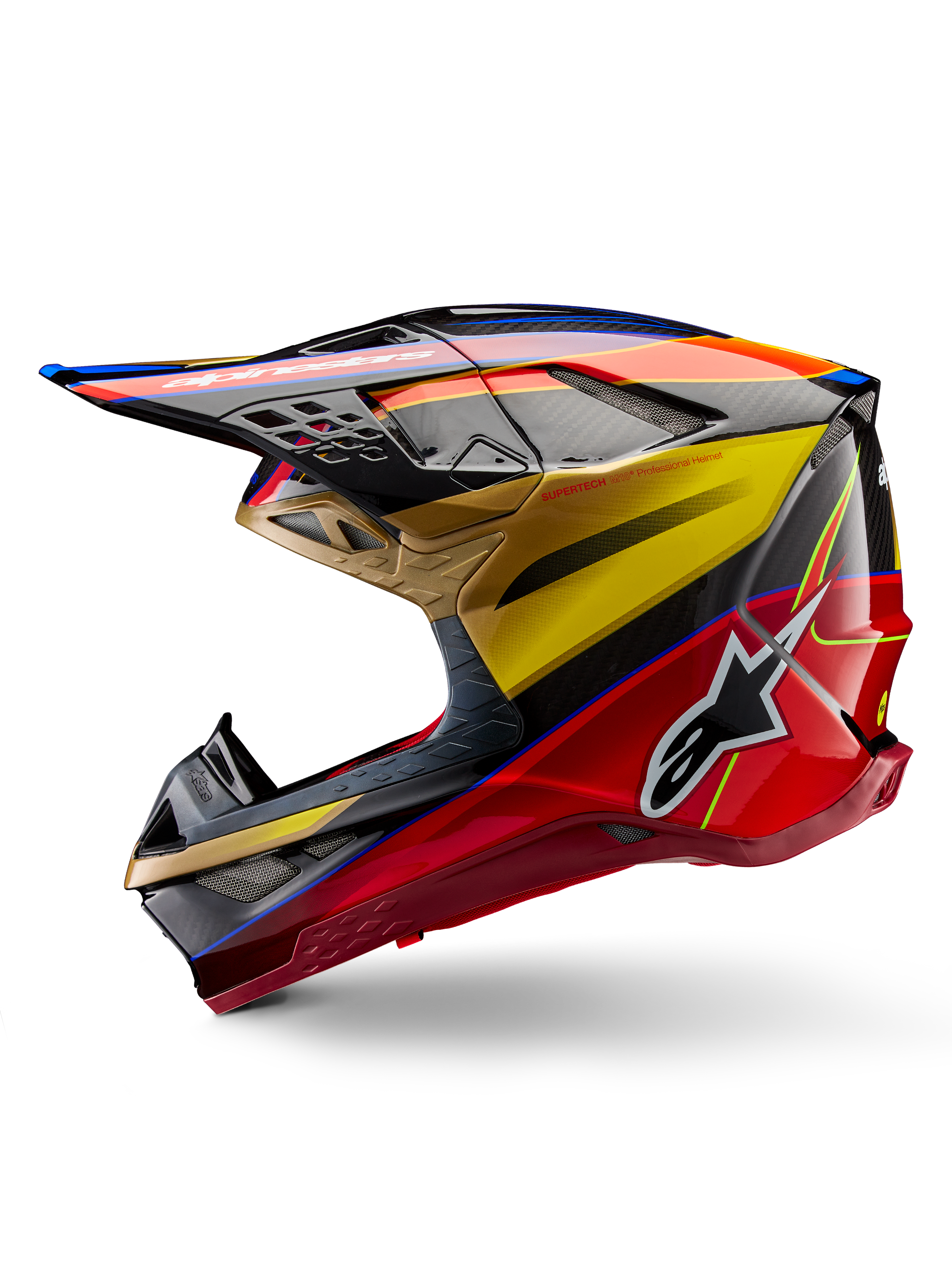 Casque Alpinestars Supertech M10 Era, casque de motocross, or jaune et rouge Rio brillant, profil latéral avec texture en fibre de carbone et graphismes audacieux, logo étoile Alpinestars, forme aérodynamique avec de nombreux orifices de ventilation, protection professionnelle pour la course tout-terrain