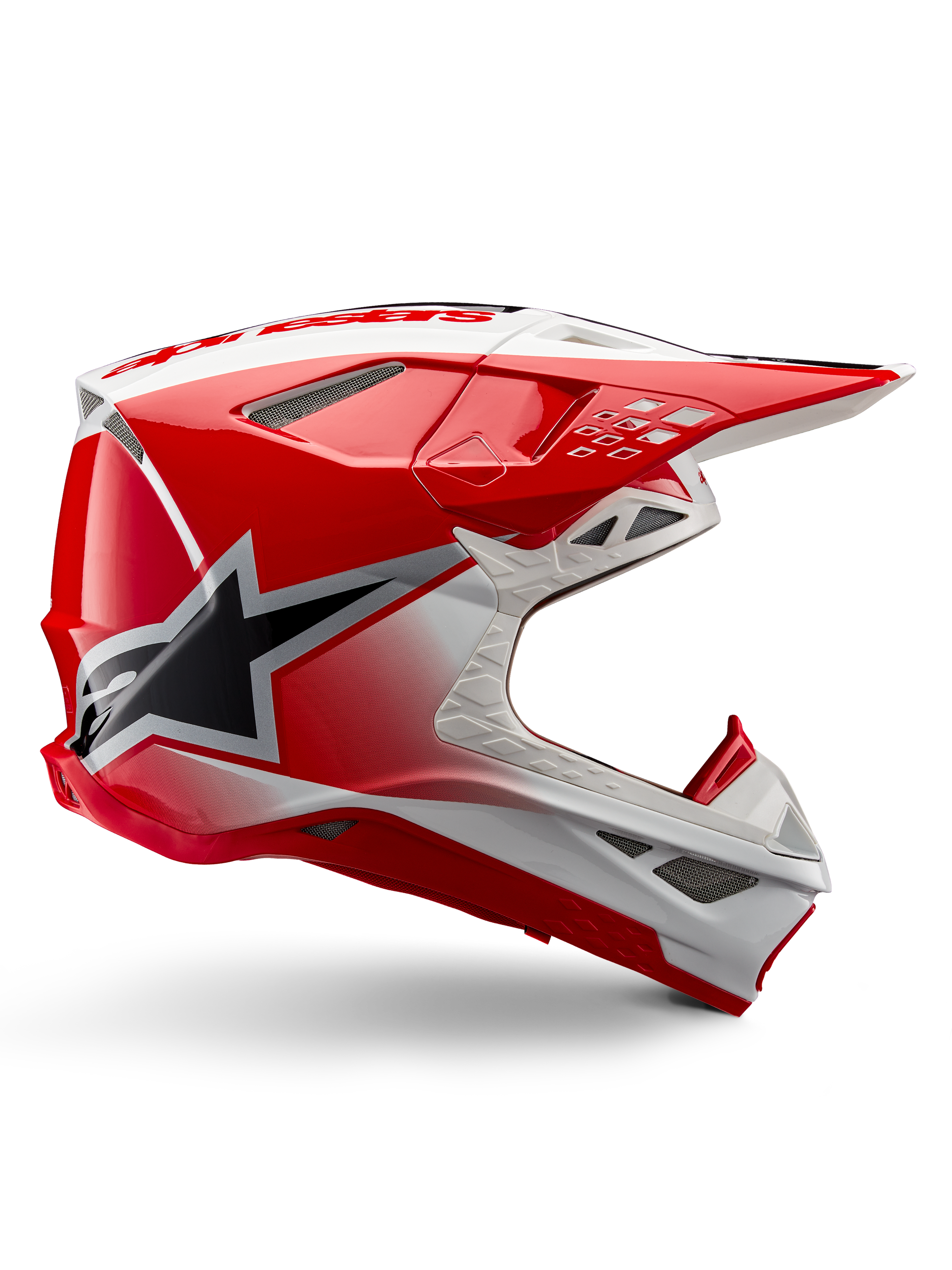 Casque Alpinestars Supertech M10 Unite, casque de motocross, rouge et blanc brillant, présentant une vue de profil avec des motifs géométriques angulaires, un graphique d'étoile noire, de multiples aérations en maille et un design aérodynamique pour la course tout-terrain
