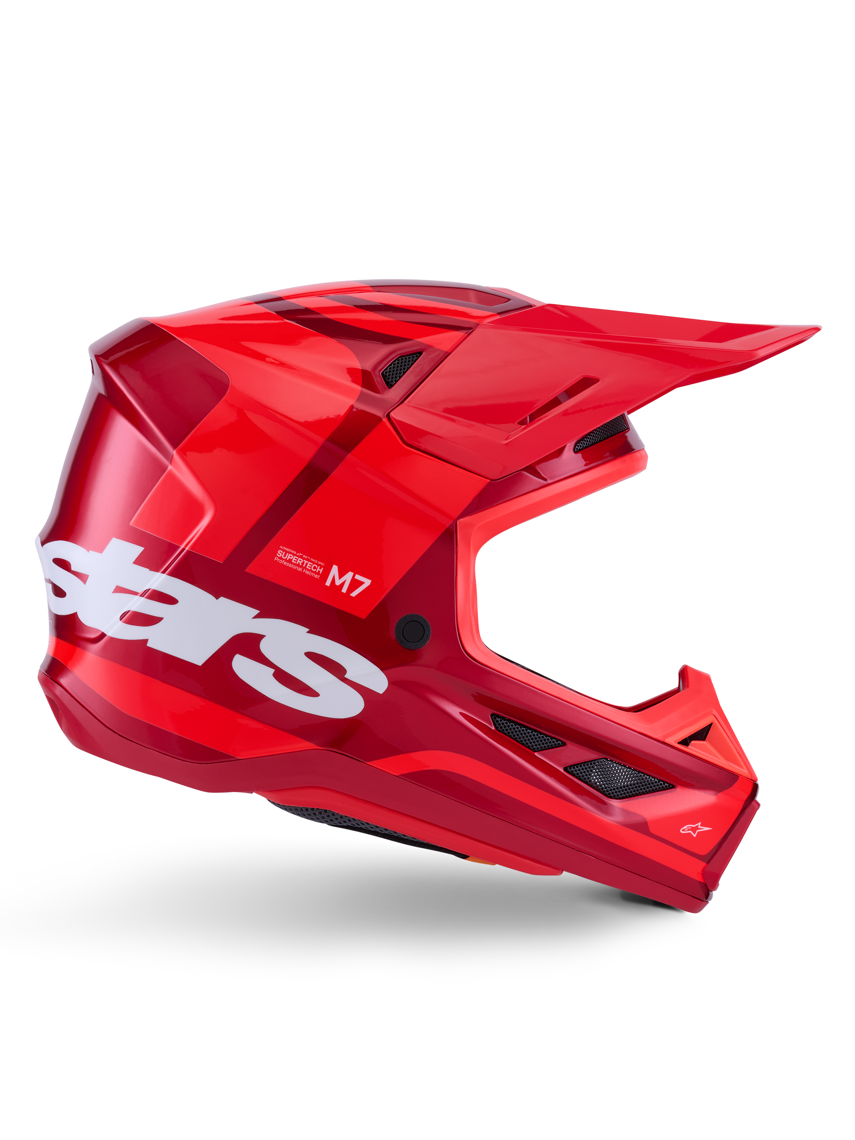 Casque Alpinestars S-M7 Core, casque de motocross, rouge brillant avec des accents rouge foncé et des logos blancs, vue latérale présentant un grand logo "stars" blanc, coque aérodynamique avec des ouvertures de ventilation en mesh et une visière proéminente