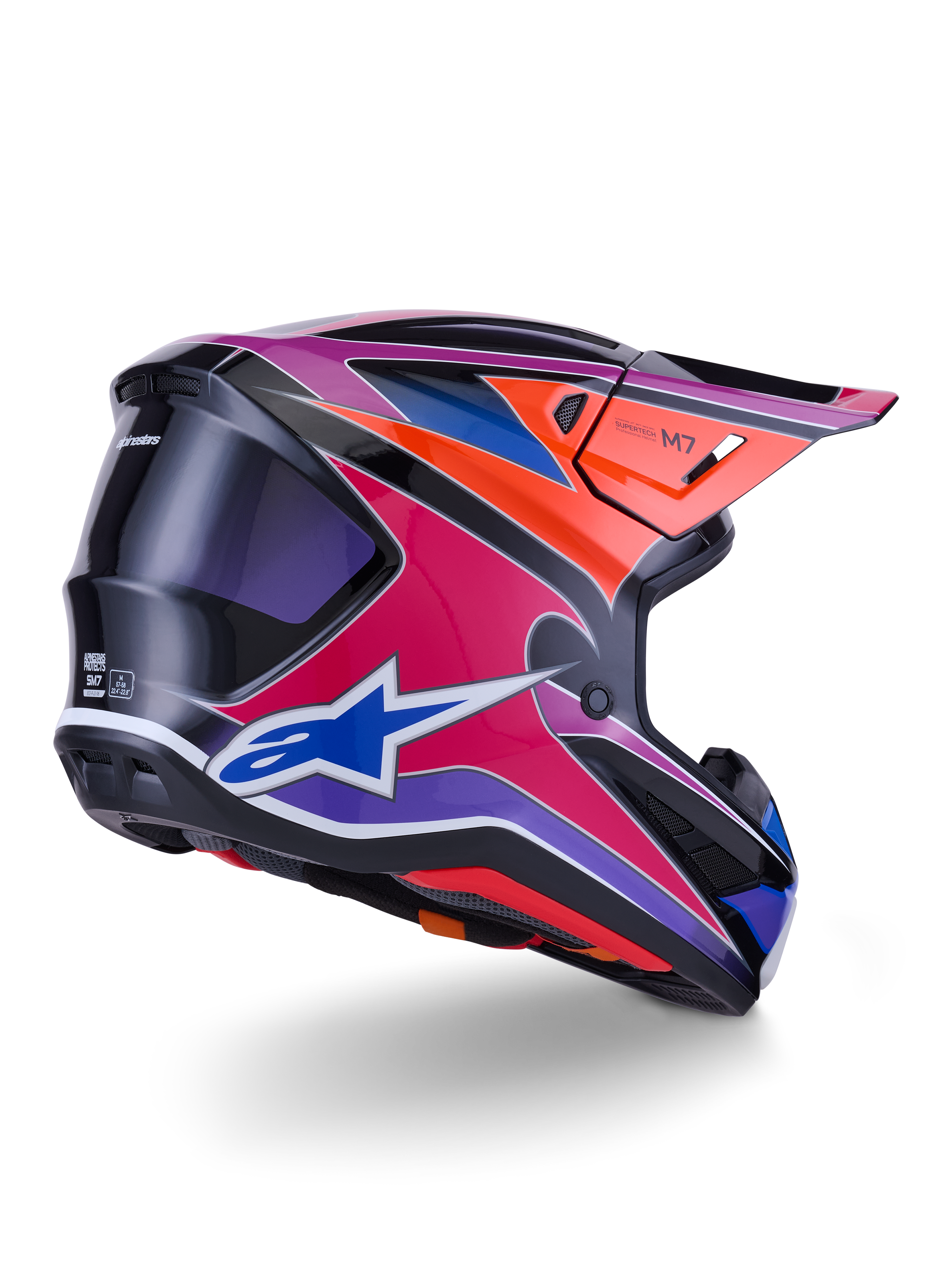 Casque Alpinestars S-M7 Fuse, casque de motocross, finition brillante bleu, violet et rose avec accents orange et noir, vue de trois-quarts arrière montrant la coque aérodynamique, la visière et les ports de ventilation, protection professionnelle pour la course tout-terrain