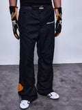 Alpinestars RSRV Arena Suit Pants, pantalon de course noir avec logos McLaren et Alpinestars, détails orange, porté avec gants noirs et orange et chaussures de course blanches