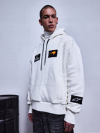 Alpinestars RSRV Rival Hoodie, sweat à capuche blanc avec patchs noirs, swoosh orange, patch étoile sur la manche, col roulé blanc en dessous, style streetwear premium