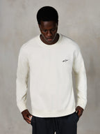 Alpinestars Essentials Ageless Crew, sweat-shirt à col rond, blanc cassé, petit logo Alpinestars noir sur la poitrine, porté par un mannequin, streetwear décontracté, polaire douce haut de gamme